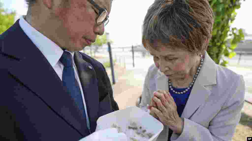 A 83 éves Tamiko Sora (jobbra), a hirosimai atomtámadás túlélője imádkozik, miután Rebun Kayo (balra), a Hirosimai Egyetem kutatója megmutatja neki a Ninoshima-szigeten talált emberi csontdarabot 2025. július 9-én Hirosimában