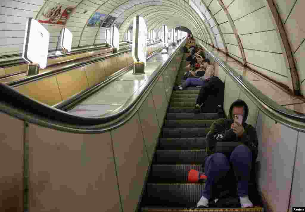 Shkallët lëvizëse të metrosë përplot me njerëz që qëndronin ulur gjatë strehimit, më 12 korrik.