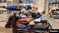 Një palestineze e zhvendosur qëndron pranë sendeve të paketuara në prag një operacioni ushtarak izraelit, në qytetin e Gazës, 8 shtator 2025.