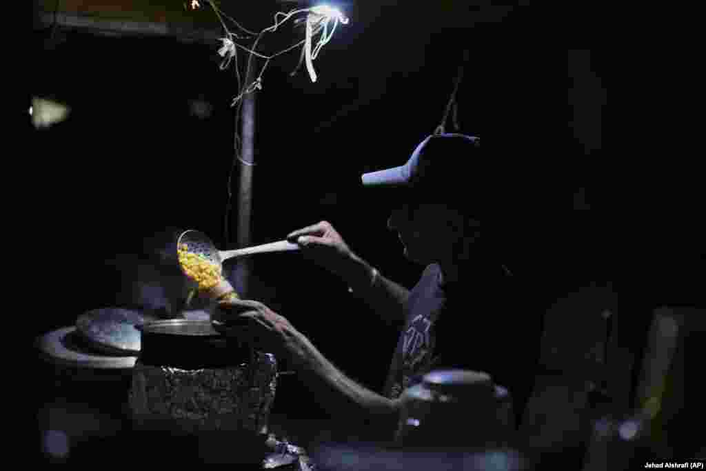 Një shitës ambulant palestinez duke përgatitur misër për ta shitur afër plazhit.