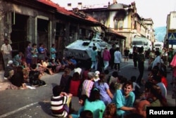 Stanovnici lijeve obale Neretve sjede nasred ulice kako bi blokirali UN-ov konvoj kamiona da napusti Mostar 26. avgusta 1993. u strahu da će snage HVO-a, koje kontroliraju desnu obalu, nastaviti granatiranje ako UN-ove trupe odu s juga zemlje.