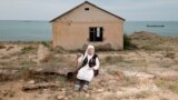 Cover for video - Woman in the village on the shores of the Caspian Sea. Photo by Ospan Ali 