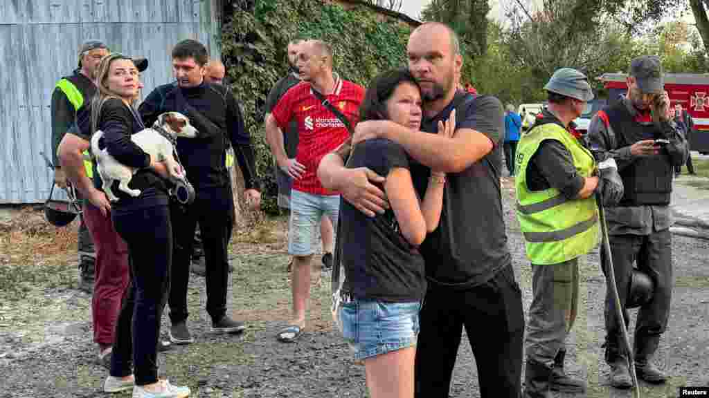 A dróntámadásban megrongálódott épület lakói a légicsapás után Harkivban augusztus 18-án