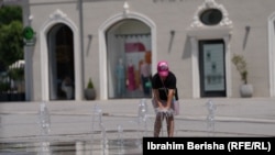 Një grua duke u freskuar në një shatërvan në Prishtinë. Fotografi ilustruese nga arkivi. 