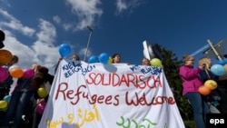 Residents welcome a bus of refugees arriving in Kiel, Germany on September 2.