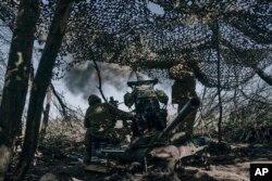 Imagine de pe frontul din Bahmut. Un soldat ucrainean lansează un proiectil asupra pozițiilor rusești.