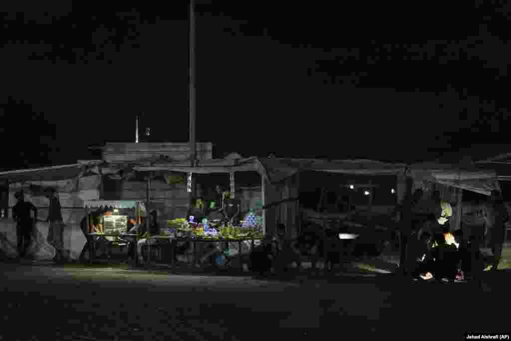 Shitës palestinezë duke biseduar rreth një tezge.