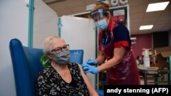 Nagy-Britanniában elkezdődött a szigetország történetének legnagyobb oltási programja. A képen egy ápoló beadja a Pfizer-BioNTech COVID-19 vakcinát Trixie Walker páciensnek egy sheffieldi kórházban, Yorkshire-ben, 2020. december 8-án. 