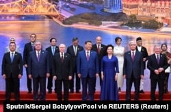 Президент Казахстана Касым-Жомарт Токаев (второй справа) и президент Узбекистана Шавкат Мирзиёев на фотосессии на полях саммита ШОС. Тяньцзинь, 31 августа 2025 года
