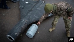 Украинский военный осматривает сбитый беспилотник. Иллюстративная фотография