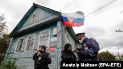 Полицай охранява избирателна секция в село Бабино, Ленинградска област, на 17 септември 2021 г. Изборите в Русия за първи път протекоха в три дни, вместо в един - от 17 до 19 септември.