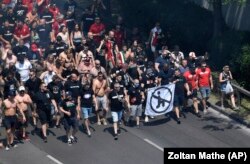 A mérkőzések előtti térdelés indulatos vitákat vált ki. Magyar szurkolók az idei Eb-n térdelésellenes jelképpel, néhány órával a Magyarország–Franciaország mérkőzés előtt, június 19-én, Budapesten. Korábban a magyar szurkolók egy része kifütyülte a fél térdre ereszkedő ír válogatott játékosait, ami nemzetközi bírálatokat váltott ki. A drukkerek viselkedése miatt a magyar válogatottnak több UEFA-mérkőzését is üres nézőtér előtt kell lejátszania a közeljövőben.