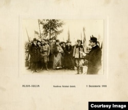 Imaginea clasică a celor doi capi ai Bisericilor Naționale: Biserica Greco-Catolică, reprezentată de Iuliu Hossu, citind Proclamația Unirii Transilvaniei cu România și Biserica Ortodoxă, înfățișată de Miron Cristea, între civili și soldați, viitorul Patriarh al României Unite.