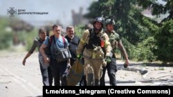 Punëtorët e emergjencave duke punuar pas një sulmi rus në Dnipropretrovsk më 24 qershor 2025. 