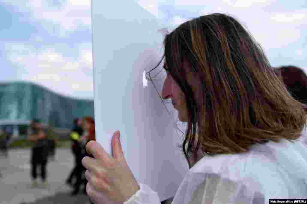 აქცია-პერფორმანსისი მონაწილე იხედება სამიზნიდან, რომელიც&nbsp;მათი თქმით არის 20-21 ივნისის ღამით მომხდარი ამბის&nbsp;სიმბოლო.