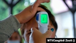 Egy diák testhőmérsékletét mérik érkezéskor a Bagaméri Általános Iskola és Alapfokú Művészeti Iskola bejáratában 2020. szeptember 29-én