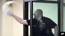 Opozantul Nika Melia, unul din liderii Coaliției pentru Schimbare, văzut aici cum aruncă cu apă spre un judecător, este unul din șase activiști condamnați la închisoare săptămâna trecută, alți doi politicieni ai opoziției pro-occidentale așteptându-și încă sentințele.