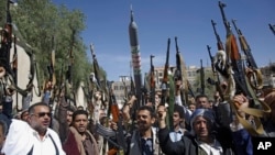 Bărbați din triburile loiale rebelilor Houthi își ridică armele în timpul unei adunări de mobilizare. Sanaa, Yemen, 25 februarie 2020. (AP Photo/Hani Mohammed)