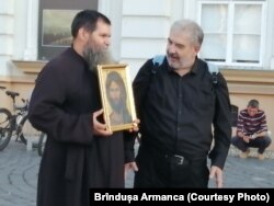 Preot ortodox cu o icoană la protestul antivacciniștilor din Timișoara