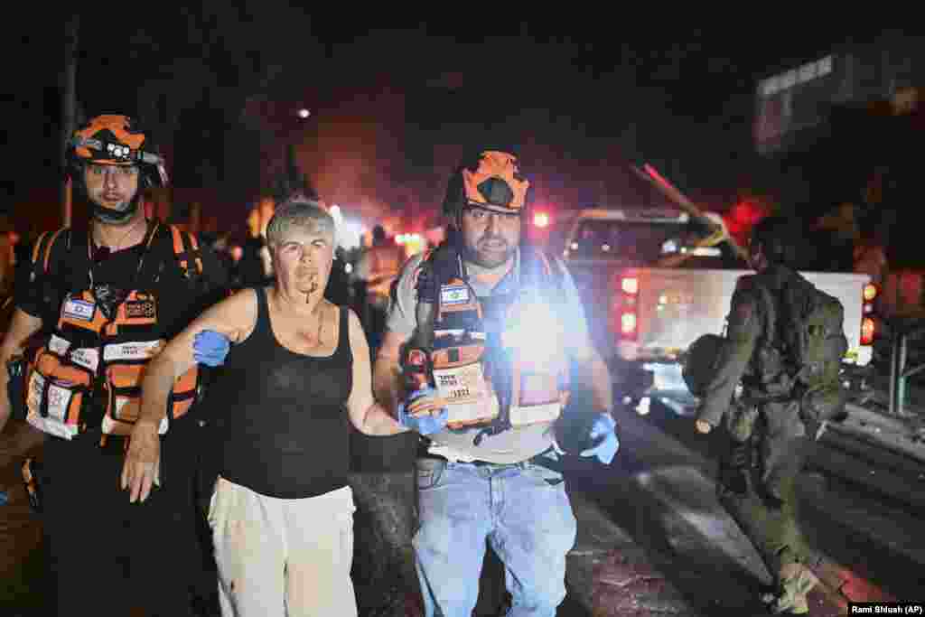 Shpëtimarë izraelitë duke evakuuar një grua të plagosur nga një vend i goditur nga një raketë e lëshuar nga Irani, në Haifa, në pjesën veriore të Izraelit, më 15 qershor.