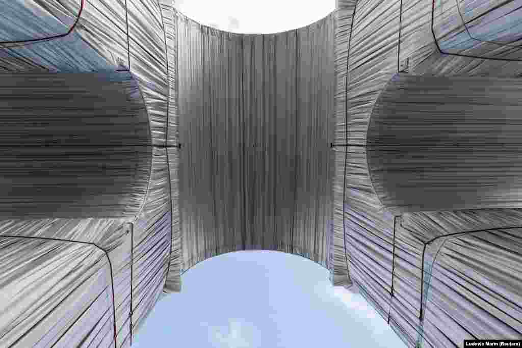 A becsomagolt Diadalív alulnézetből. Javacsov azt mondta a CNN-nek, hogy amikor Christo az ötvenes években Szófiában tanult, az egyik tájképének borús, sötét eget festett, mire azt mondták neki, úgy látszik, &bdquo;mintha az ég elnyomná a parasztokat, és ez nagy vihart kavart. Utálta a rendszer ránehezedő súlyát&rdquo; &ndash; emlékszik vissza az unokaöccs