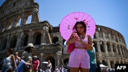 Një grua duke u mbrojtur nga dielli në Romë, më 1 korrik.