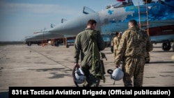 Ukrajinski piloti hodaju pored borbenih aviona Su-27 u bazi u Ukrajini