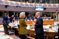 Președinta Comisiei Europene, Ursula von der Leyen, vorbește cu cancelarul german Olaf Scholz în timpul unei mese rotunde la summitul UE de la Bruxelles, 20 martie 2025.
