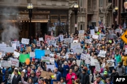 Demonstranții mărșăluiesc pe străzi în timpul marșului „Hands Off - Massachusetts!” în Boston, Massachusetts, pe 5 aprilie 2025.