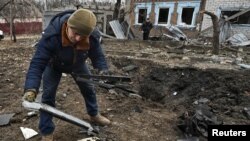 Muškarac pregleda djelove ruskog kamikaze drona koji je pogodio stambeno naselje u Zaporožju, u Ukrajini. 25.novembar 2024.godine