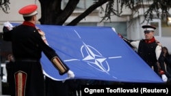 Членови на почесната гарда го подигнаа знамето на НАТО пред парламентот на Северна Македонија за да ја одбележат ратификацијата на пристапувањето во НАТО, во Скопје, 11 февруари 2020 година