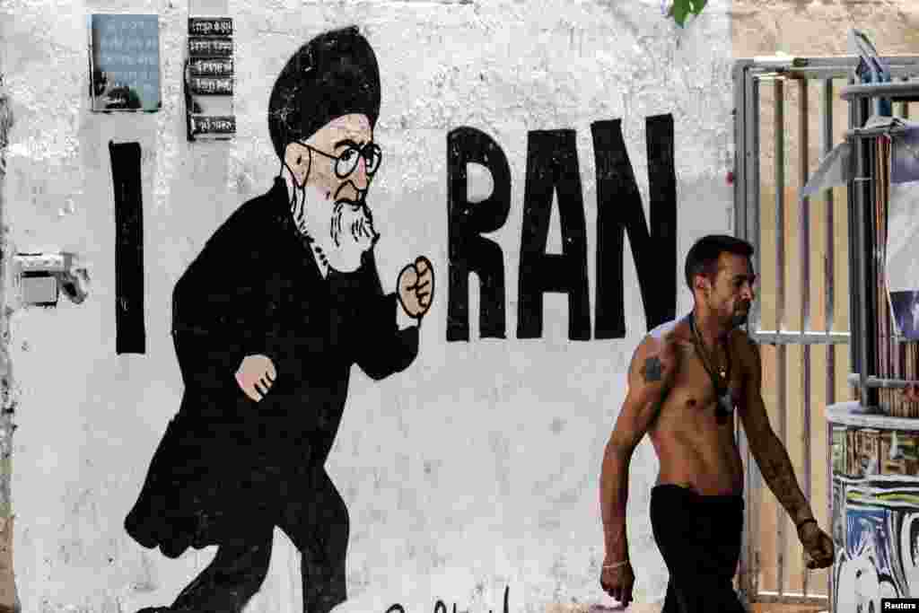 Израильтянин проходит мимо нового граффити верховного лидера Ирана аятоллы Али Хаменеи после 12-дневной войны между Израилем и Ираном в Тель-Авиве, Израиль 8 июля 2025 года REUTERS/Nir Elias