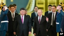 Președintele rus Vladimir Putin (centru dreapta) îl întâmpină pe omologul său chinez, Xi Jinping (centru stânga), pentru discuții la Kremlin, în luna iunie. 