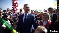 Karol Nawrocki, candidatul național-conservatorilor la președinția Poloniei, sărbătorind Floriile pe 13 aprilie, în mijlocul mulțimii, în mica localitate Lyse din nord-estul țării.