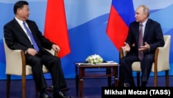 Russian President Vladimir Putin (right) speaks with Chinese President Xi Jinping during their meeting on the sidelines of the Eastern Economic Forum in Vladivostok on September 11.