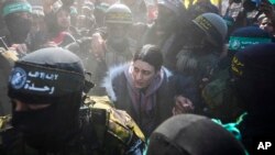  29-годишната Арбел Йехуд от израелската армия е ескортирана от бойци ха Хамас, за да бъде предадена на Червения кръст, Хан Юнис, Ивицата Газа, 30 януари 2025 г.