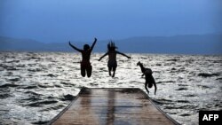 Архивска фотографија: Девојки скокаат во Охридското Езеро на зајдисонце 