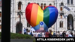 Flashmobbal tiltakozak aktivisták a homofób pedofiltörvény hatálybalépése ellen a parlament előtt Budapesten, 2021. július 8-án.