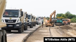 Teherautók és munkagépek az M35 autópálya és a 354. számú főút átépítés alatt álló csomópontjánál, Debrecen határában 2021. július 23-án