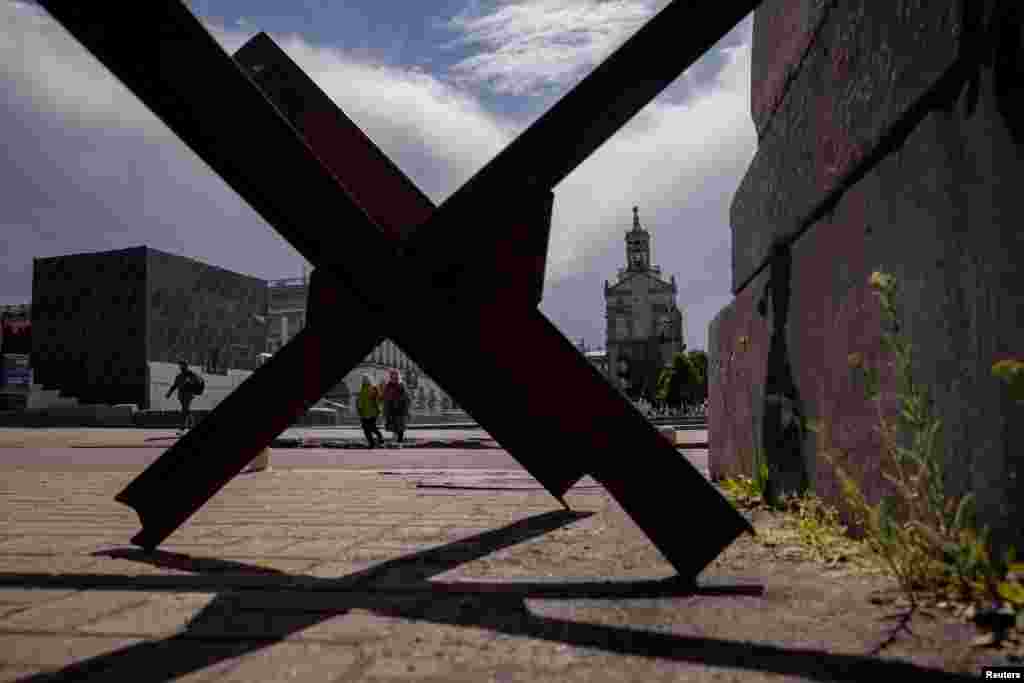 Ljudi hodaju u blizini protutenkovske barijere na Trgu nezavisnosti u glavnom gradu Ukrajine, Kijevu.