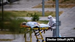 РУСИЈА - Медицинско лице придружува жена во болница каде се лекуваат пациенти од КОвид-19. 30 јуни 2021 година. 