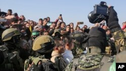 Газа - Милитантите на Хамас и на Исламски џихад ја обезбедуваат областа додека претставниците на Црвениот крст го чекаат предавањето на тајландските и израелските заложници во Кан Јунис, јужниот дел на Појасот Газа, 30 јануари 2025 година. 