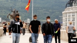 Илустрација - Луѓе со заштитни маски на Камени мост во Скопје