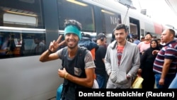 Refugiaţi şi imigranţi, luând trenul spre Germania, din gara de la Viena, 5 septembrie 2015