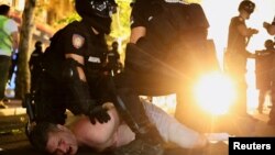 Служители на реда задържат демонстрант по време на антиправителствен протест с искане за предсрочни избори в Белград, Сърбия, 28 юни 2025 г.