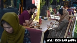 Un cuplu la o cafenea din Kabul, în august 2019. Acum, mulți tineri din capitala afgană spun că nu își permit să mănânce în oraș din cauza crizei economice devastatoare.