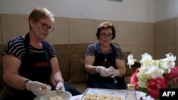 Eftali Qerimi (majtas) dhe Odeta Nasi, duke përgatitur ëmbëlsira tradicionale të Përmetit.