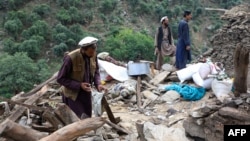 Bărbați afgani caută printre ruinele caselor distruse după un nou cutremur care a avut loc în provincia Kunar, în estul Afganistanului. Fotografie din 4 septembrie 2025.