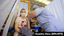 O tânără din R. Moldova își administrează vaccinul anti-COVID-19 în cadrul unui marafon la Palatul Republicii, iunie, 2021