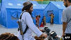 Un membru al forțelor de securitate talibane pe motocicletă într-un tabără improvizată pentru refugiații afgani deportați din Iran, în Kabul, pe 16 iulie 2025.
